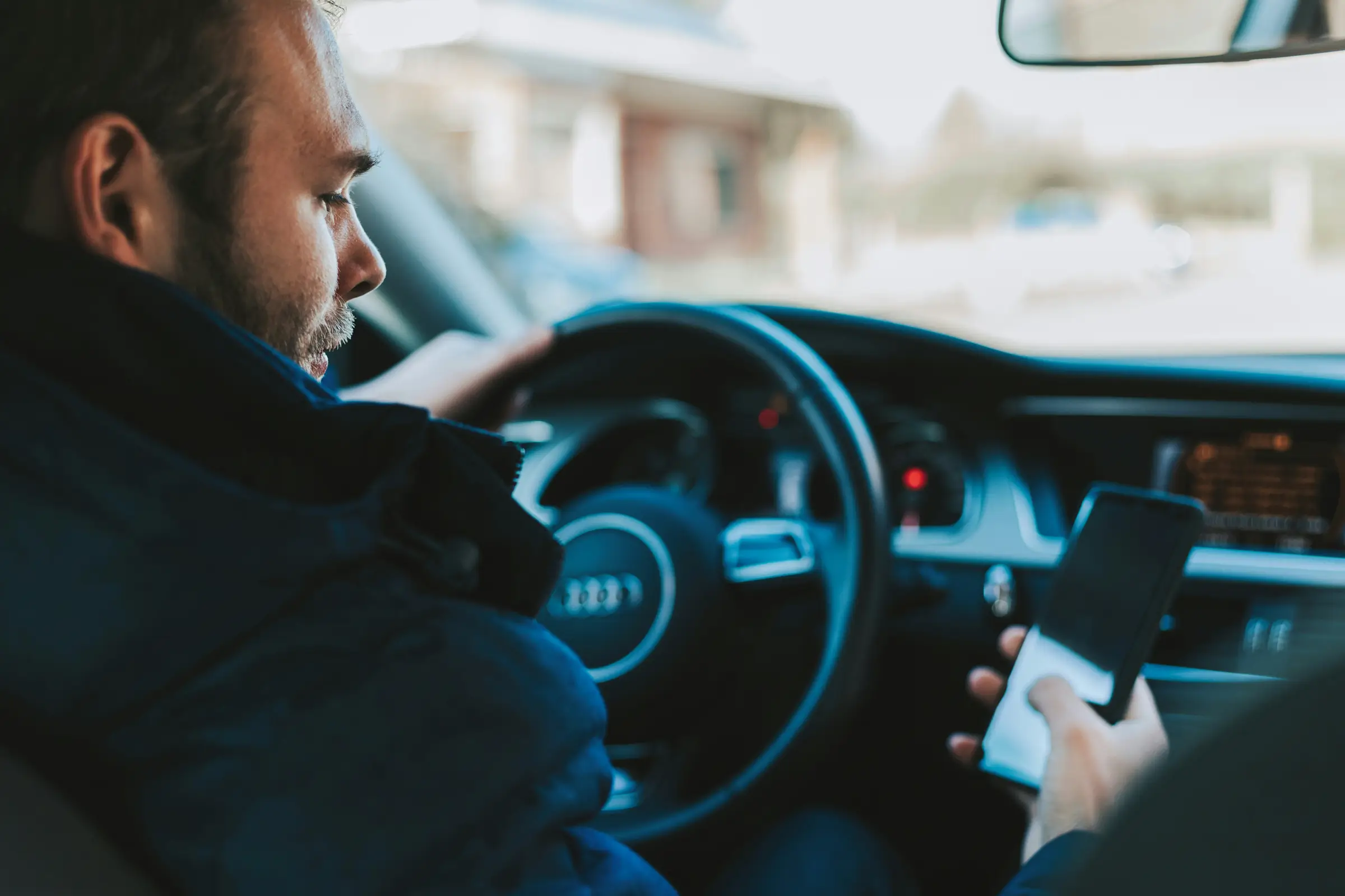 Guy texting on phone while driving