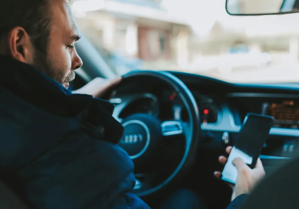 Guy texting on phone while driving