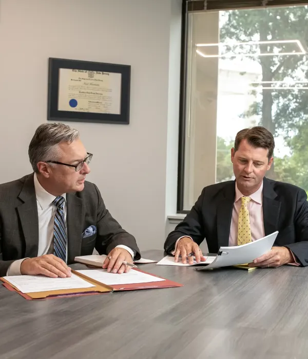 Two Leonard Injury Firm attorneys reviewing documents together at a conference table